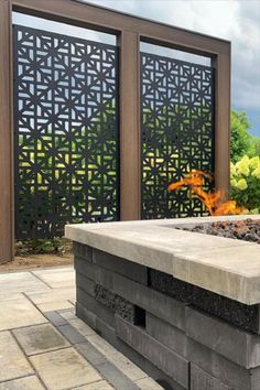 an outdoor fire pit with decorative screens in the background