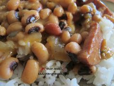 beans and sausage are on top of white rice