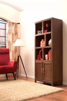 a living room with a red chair and bookcase