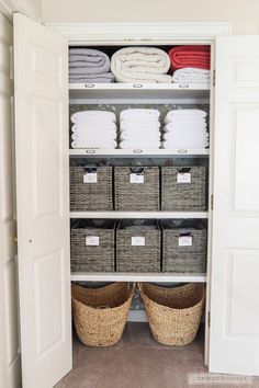 an organized closet with baskets and folded towels