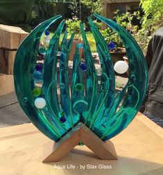 a green glass sculpture sitting on top of a wooden table