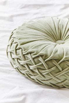 a large round pillow sitting on top of a bed