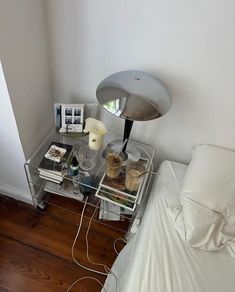 a bed room with a neatly made bed and a lamp on the nightstand next to it