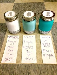 three jars with labels on them sitting on the floor next to each other and some writing