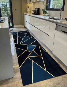 a kitchen area with blue and gold rugs on the floor