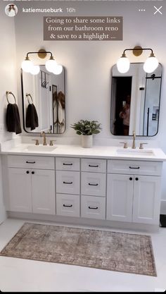 a bathroom with two sinks, mirrors and lights on the wall next to a rug