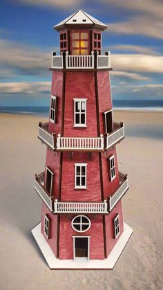 a red and white building sitting on top of a sandy beach