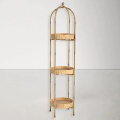 a three tiered shelf with wicker baskets on it