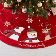 a christmas tree skirt with three snowmen on it