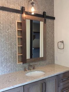 a bathroom with a sink, mirror and shelving unit in the middle of it