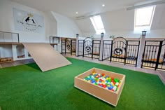 an indoor play area with artificial grass and toys in the box on the green floor