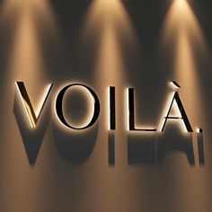 the word volta is illuminated by three spotlights in front of a wall with lights