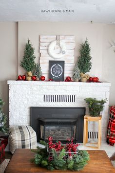 a living room decorated for christmas with red and green decorations on the fireplace mantel