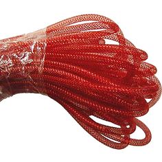 a red string with white dots on it is wrapped in plastic and sits on a white surface