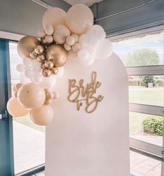 balloons are hanging from the side of a white wall that reads, bride to be