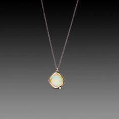 An organically-shaped, faceted Ethiopian opal, wrapped in a warm 22k gold bezel, and accented by a single, twinkling white diamond is suspended from an oxidized sterling silver chain in this magically stunning necklace. The opal is backed with sterling silver, and measures approximately 1/2 inch tall. Matte finish. Yellow Gold Opal Pendant Necklace, Elegant Ethiopian Opal Necklace In Yellow Gold, Fine Jewelry Ethiopian Opal Pendant, Yellow Gold Opal Teardrop Pendant Necklace, Yellow Gold Ethiopian Opal Necklace For Gift, Ethiopian Opal Pendant In Fine Jewelry Style, Yellow Gold Opal Teardrop Pendant Jewelry, Gold Ethiopian Opal Minimalist Jewelry, Yellow Gold Teardrop Opal Necklace