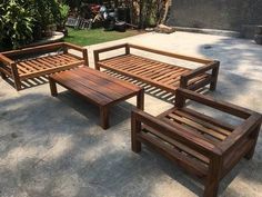 three wooden benches sitting next to each other on a cement floor in front of a house