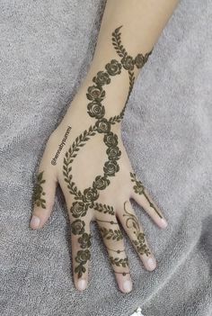 a woman's hand with henna tattoos on it