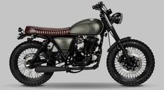 a motorcycle is shown in grey and brown leather on a gray background, it appears to be an old model