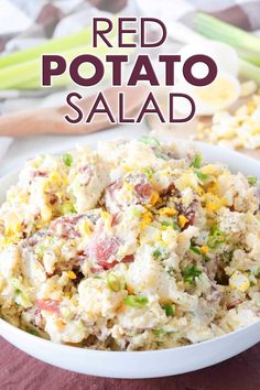 red potato salad in a white bowl with green onions and celery on the side