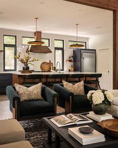 a living room filled with furniture next to a kitchen