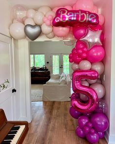 the balloon arch is decorated with pink, purple and white balloons