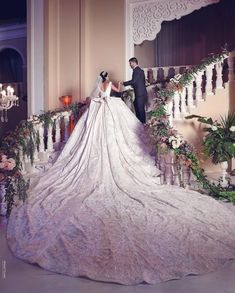 a bride and groom are standing on the stairs at their wedding ceremony in an elegant venue