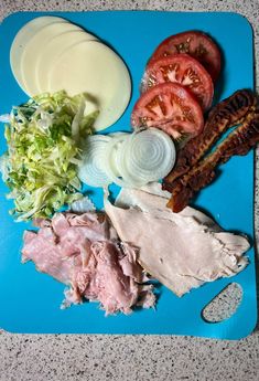 a blue cutting board topped with meat and veggies