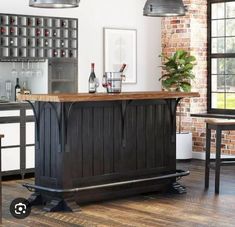 a kitchen with an island in the middle and wine bottles on the wall behind it