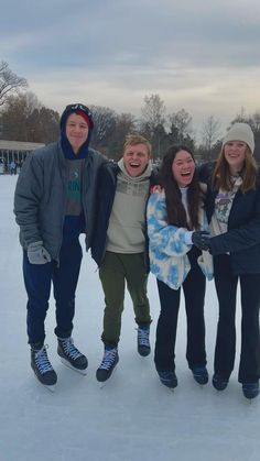 four people standing in the snow posing for a photo