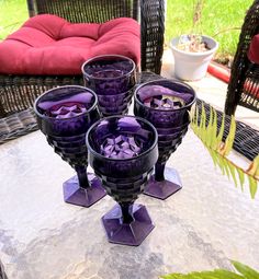 three purple glasses sitting on top of a table