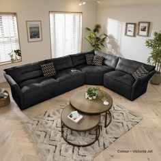 a living room with a large black couch and coffee table