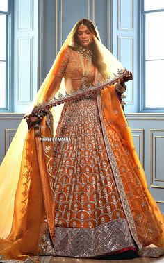 a woman in an orange and gold bridal gown