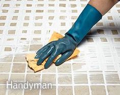 a person in blue gloves and rubber gloves cleaning tile floor with a yellow cloth on it