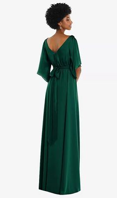 a woman in a long green dress with an open back and tie at the waist