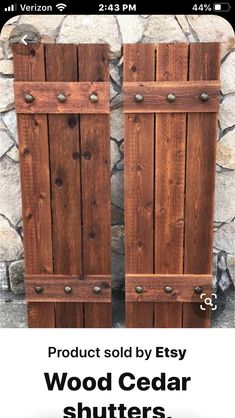 two wooden doors sitting next to each other on top of a stone wall in front of a rock wall