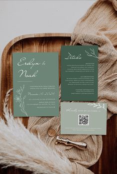 the wedding stationery is laid out on top of a wooden tray with furnishing