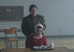 a woman is getting her hair cut by an older lady at a table with milk in front of her