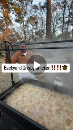 a man standing in front of an outdoor grill with food cooking on top of it