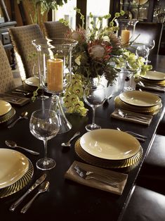 a dining room table is set with gold plates and place settings for four people to sit at