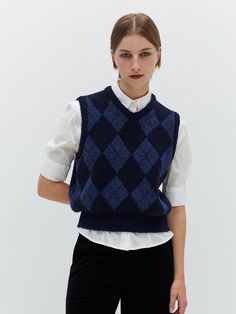 This is a sleeveless knit vest featuring a classic argyle pattern. The ribbed trim around the neckline and armholes suggests a snug and comfortable fit. The knit texture is prominent, indicating the garment is likely to provide warmth despite being sleeveless.- The argyle pattern gives the vest a traditional, preppy look, making it suitable for layering over shirts.- The ribbed edging contributes to the garment's shape retention and adds an extra detail in the finish.- This type of vest is often associated with smart casual attire and can be a versatile piece in a wardrobe. Preppy Vest, Argyle Vest, Argyle Sweater Vest, Argyle Pattern, Knit Texture, Preppy Look, Sleeveless Knit, Argyle Sweater, Street Outfit