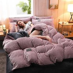 a woman laying on top of a bed covered in pillows