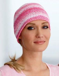 a woman wearing a pink and white knitted hat