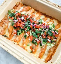 an enchilada in a baking dish with toppings on top, ready to be eaten