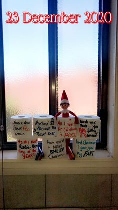 an elf sitting on top of a window sill next to a sign that says 25 december