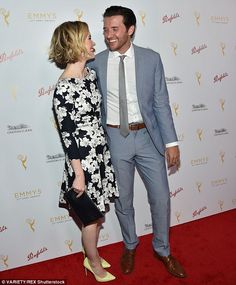 a man and woman standing next to each other on a red carpet at an event