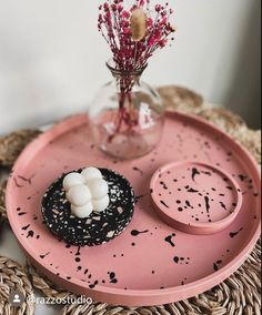 a pink tray topped with a cupcake covered in marshmallows next to a vase filled with flowers