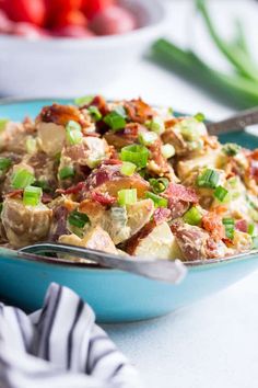 a blue bowl filled with potato salad on top of a table