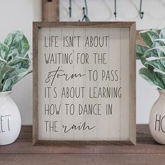 two vases with plants in them and a sign that says life isn't about waiting for the storm to pass, it's about learning how to dance in the rain