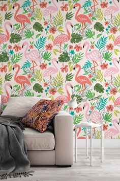 a living room with flamingos and tropical leaves on the wall, in front of a white couch